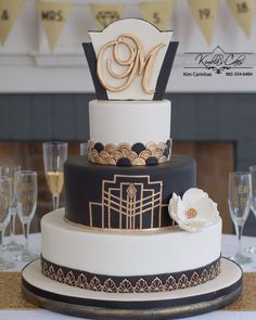 a three tiered cake sitting on top of a table next to wine glasses and napkins