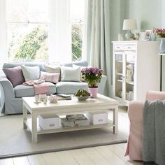 a living room filled with lots of furniture and flowers on top of a coffee table