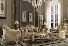 an ornate living room with chandelier, couch and two loveseat set