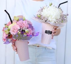 two women holding bouquets of flowers in their hands