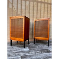 two wooden cabinets sitting next to each other on top of a wood floored floor