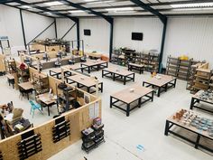 the inside of a warehouse with tables and benches