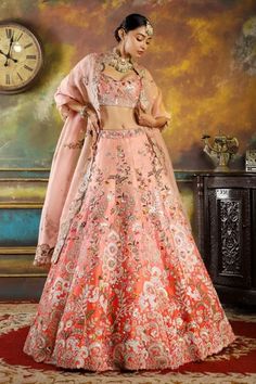 Pink ombre raw silk lehenga with attached can-can, all over royal flower pattern resham and dabka embroidery. Paired with embroidered padded deep round neck blouse and organza dupatta with cut work border.
Components: 3
Pattern: Hand Embroidered
Type Of Work: Resham and Dabka Work
Neckline: Deep Round Neck
Sleeve Type: Sleeveless
Fabric: Raw Silk, Organza
Color: Pink
Other Details: 
Embroidered dupatta
Cut work border details
Panelled lehenga
Note: The necklace worn by the model is not for sale Dabka Work, Baju Kahwin, Raw Silk Lehenga, Mehendi Outfits, Bridal Lehenga Collection, Ombre Pink, Red Lehenga, Embroidered Lehenga, Indian Wedding Wear