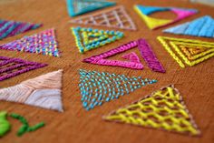 a close up of a piece of cloth with different colored stitchs on it