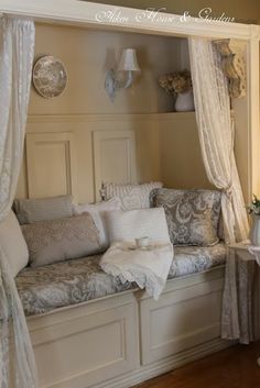 a living room filled with lots of furniture next to a window covered in white curtains