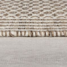 a close up view of an area rug on the floor with white and brown stripes