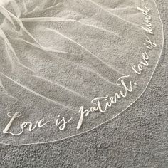 a clear glass plate with the words love is patient written in white ink on it