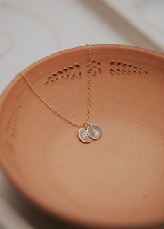 Our sweet, tiny dot stamped with one of our little symbol stamps and/or initials. A solid 9mm disc is hand-stamped and attached to a 16" or 18” delicate cable chain. Digits, Initials & Symbols available - see the photo chart. Available in 14kt Gold Fill + Sterling Silver. To ensure pendants remain on the delicate chain, pendants are intentionally designed to not slide on and off the chain. If you need assistance adding a pendant to a Tiny Dot Necklace you already own, please email us at hello@he