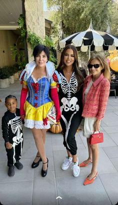 three women and a boy are dressed up as disney princesses in costumes for halloween