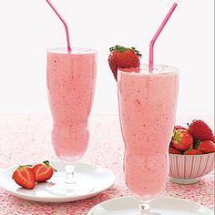 two glasses with strawberries in them on a table