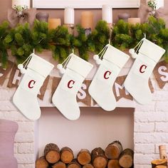 christmas stockings hanging from a mantel over logs