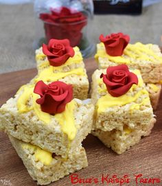 four pieces of rice krispy treats with yellow icing and red roses on top