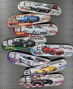 several skateboards are lined up on a metal surface with cars painted on the boards