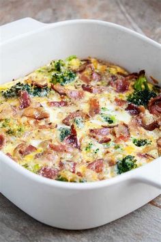 a casserole dish with bacon and broccoli in it on a table