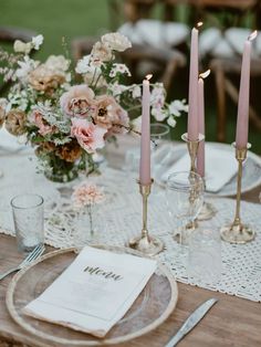 the table is set with pink candles and white place settings for an elegant wedding reception