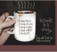 a hand holding a coffee mug with writing on it