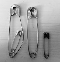 three pairs of scissors sitting next to each other on a white surface with metal handles