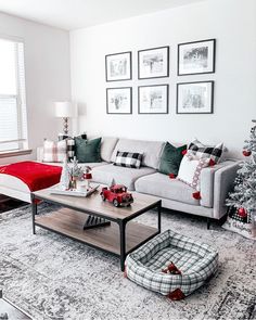 a living room decorated for christmas with red and green decorations on the couches, coffee table and ottoman