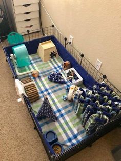 a blue wagon filled with lots of items on top of a carpeted floor next to a wall