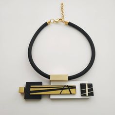 "A unique black white and gold statement necklace. This necklace will star with a classic black dress on any occasion. Definitely a necklace for a stylish modern women! Lightweight necklace. * * * * * * * * * * * Length: 18\"/46c\"m + 3\"/7.5c\"m extender. Maximum length: 21\"/53.5c\"m Need a different length? message me about it. Central element measurements: width: 5.7\"/14.5c\"m height: 1.8\"/4.5c\"m maximum thickness: 0.6\"/15 m\"m Materials: 0.31\"/8 m\"m thick black silicon cord 0.12\"/3m\ Modern Black Necklace For Evening, Bold Black Necklace For Gifts, Bold Black Necklace For Gift, Unique Black Geometric Jewelry, Modern Black Geometric Necklace, Geometric Black Necklace For Gift, Black Geometric Necklace For Gift, Black And Gold Necklace, Classic Black Dress