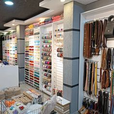 the inside of a shoe store with lots of shoes hanging on the walls and shelves