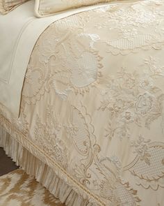 an image of a bed that is made up with white and beige bedspreads