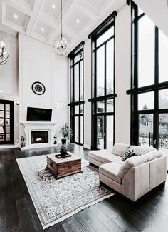 a living room filled with furniture and large windows