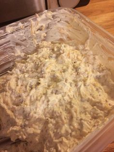 an uncooked casserole dish in a plastic container on a wooden table