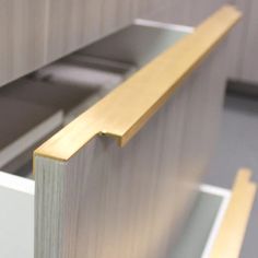 a close up view of the corner of a cabinet with wood and metal trims