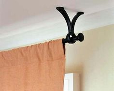 the curtain is hanging on the wall with two black hooks attached to it's side