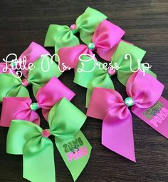 several pink and green bows on a wooden table with the words happy mom's day