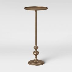 a tall brass candle holder on a white background