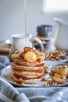 a stack of pancakes with syrup being drizzled on top