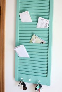 a wall mounted mail and key holder with several keys hanging on the side of it