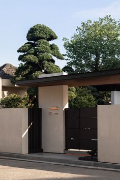 a house with a gate and trees in the background