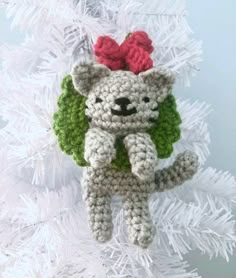 a crocheted cat ornament hanging from a white christmas tree