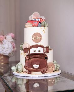 a three tiered cake with cars on it