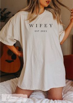 a woman wearing a white t - shirt with the word wife on it