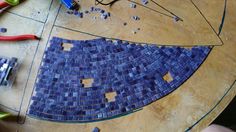 a table that has some kind of blue mosaic tile on it, and tools around it