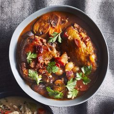 two bowls filled with food sitting on top of a cloth covered table next to each other