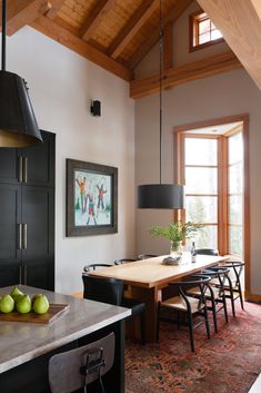 a dining room table with chairs and fruit on it