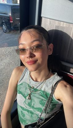 a woman sitting in the back of a bus with her hand on her hip and wearing glasses