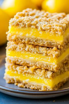 three pieces of lemon crumb cake on a plate with some lemons in the background