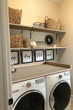 a washer and dryer in a small room with baskets on the shelves above them