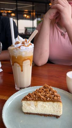 a piece of cheesecake on a plate next to a drink