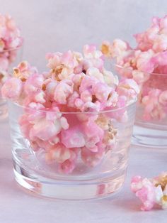 a glass bowl filled with pink popcorn sitting on top of a table