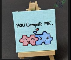 an easel with a painting on it that says you complete me and two hearts