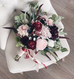 a bouquet of flowers sitting on top of a white chair