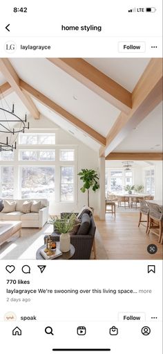 a living room filled with furniture and a large window covered in wood planks on the ceiling