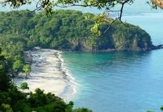 the beach is surrounded by green trees and blue water